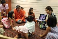 Participants gather to watch a short film depicting the ways in which children in rural villages in India learn through play in outdoor spaces.