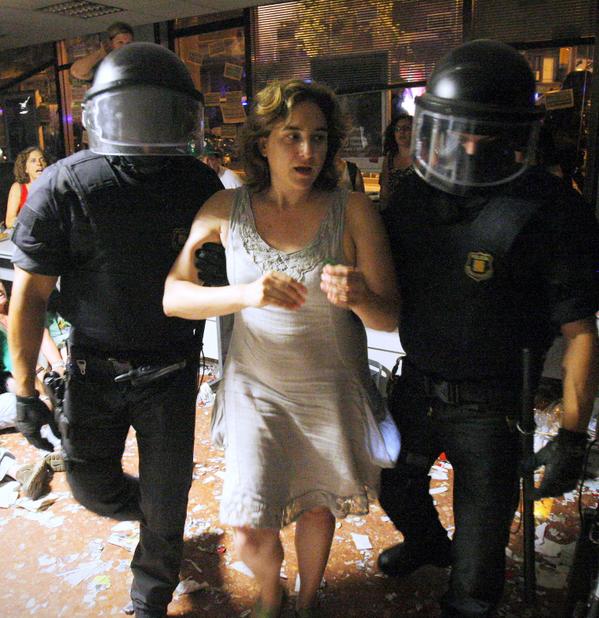 Ada Colau is escorted out by riot police officers after occupying a bank in Barcelona, Spain in 2013. Now she is Barcelona's next Mayor.